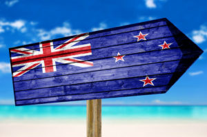 New Zealand Flag wooden sign on beach background